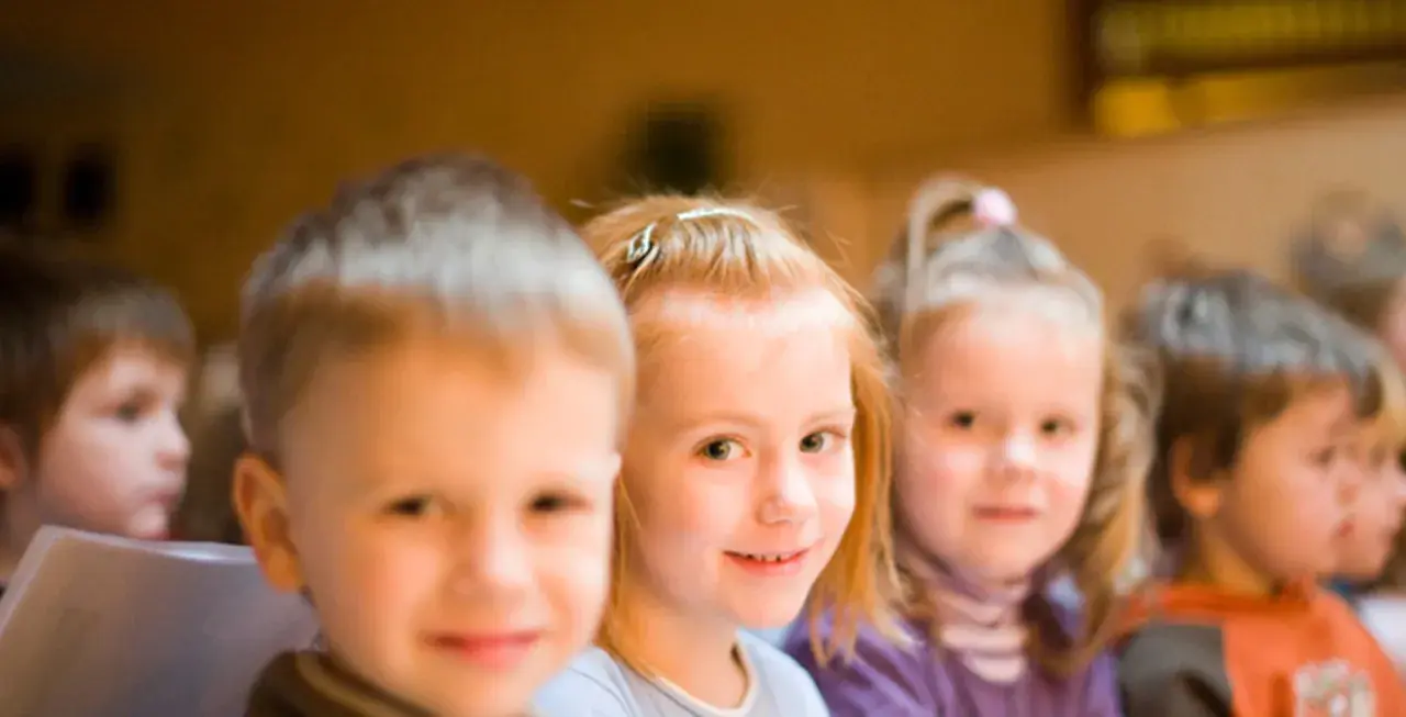 Kinder lächeln, während sie an einer episkopalen Erziehung teilnehmen.