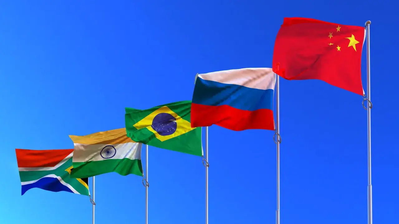 Fünf Flaggen (Südafrika, Indien, Brasilien, Russland, China) wehen im Wind. Die BRICS-Bedeutung wird durch diese Länder repräsentiert, die eine wachsende globale Rolle spielen.