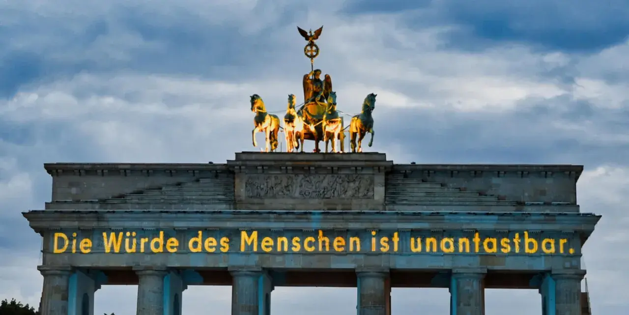 Brandenburger Tor mit leuchtender Botschaft "Die Würde des Menschen ist unantastbar." Ein Symbol für Freiheit und den Tag der Befreiung.