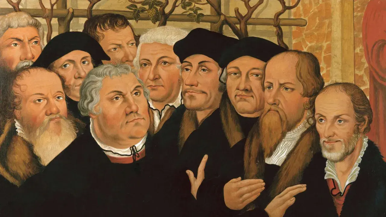 Porträtgruppe von Reformatoren, darunter Martin Luther und John Calvin, mit ernsten Blicken und prächtigen Gewändern.