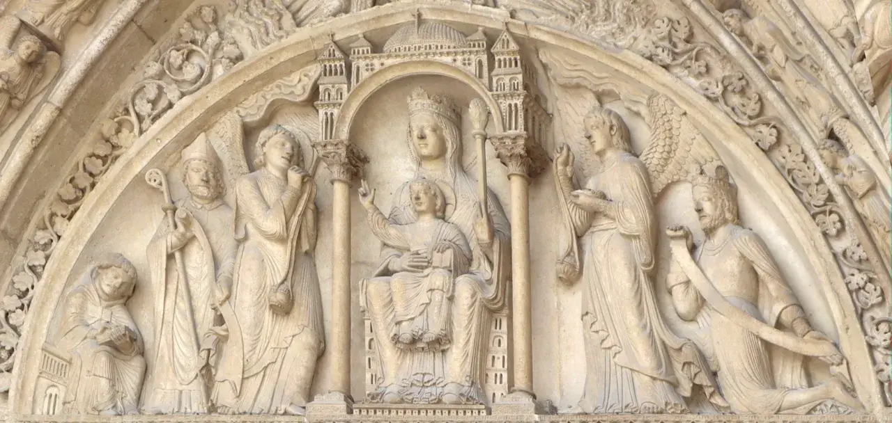 Steinrelief mit Maria und Kind, flankiert von Heiligen und Engeln. Die Bedeutung von Saint Germain wird hier durch die Darstellung von Heiligen und biblischen Szenen unterstrichen.