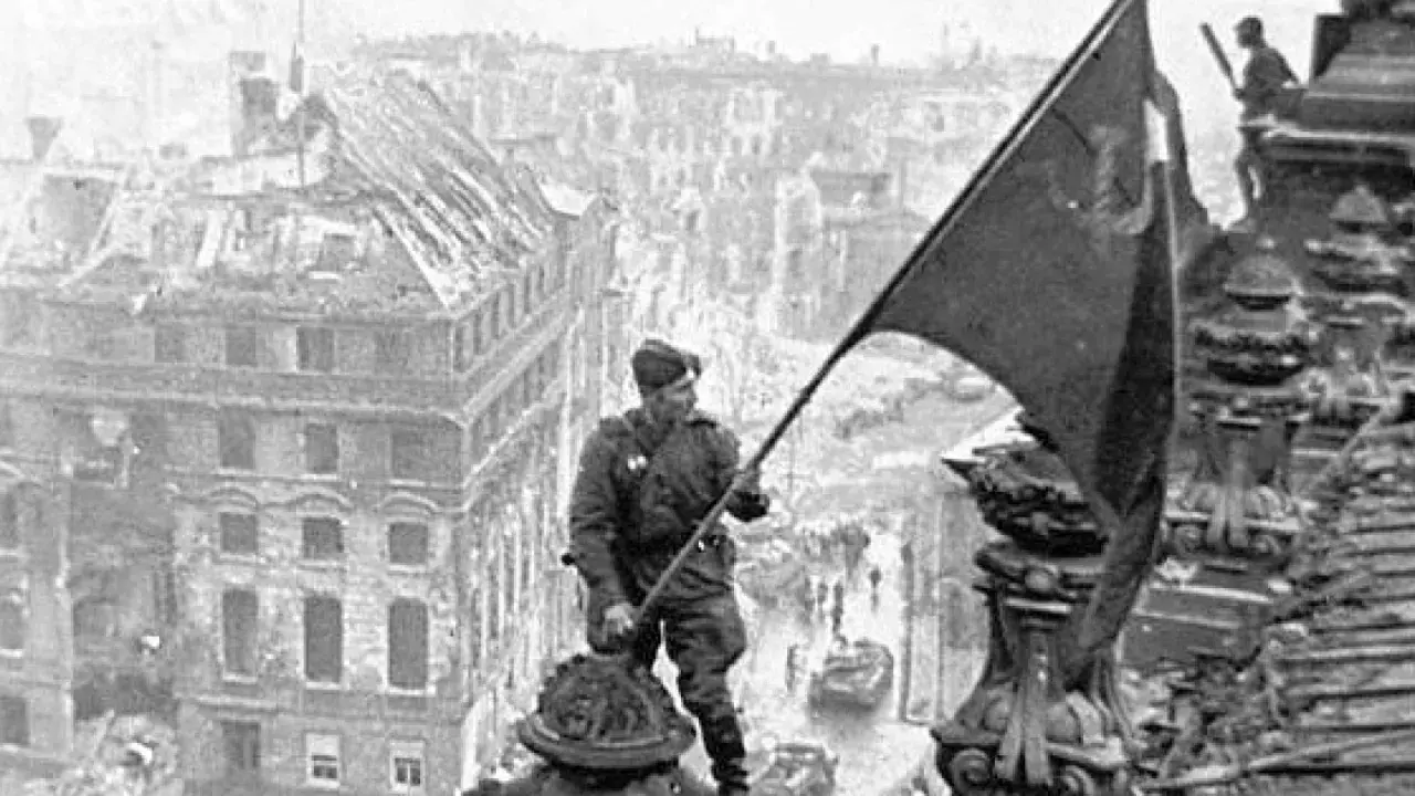 Ein Soldat hisst am 8. Mai die Flagge über den Ruinen Berlins.