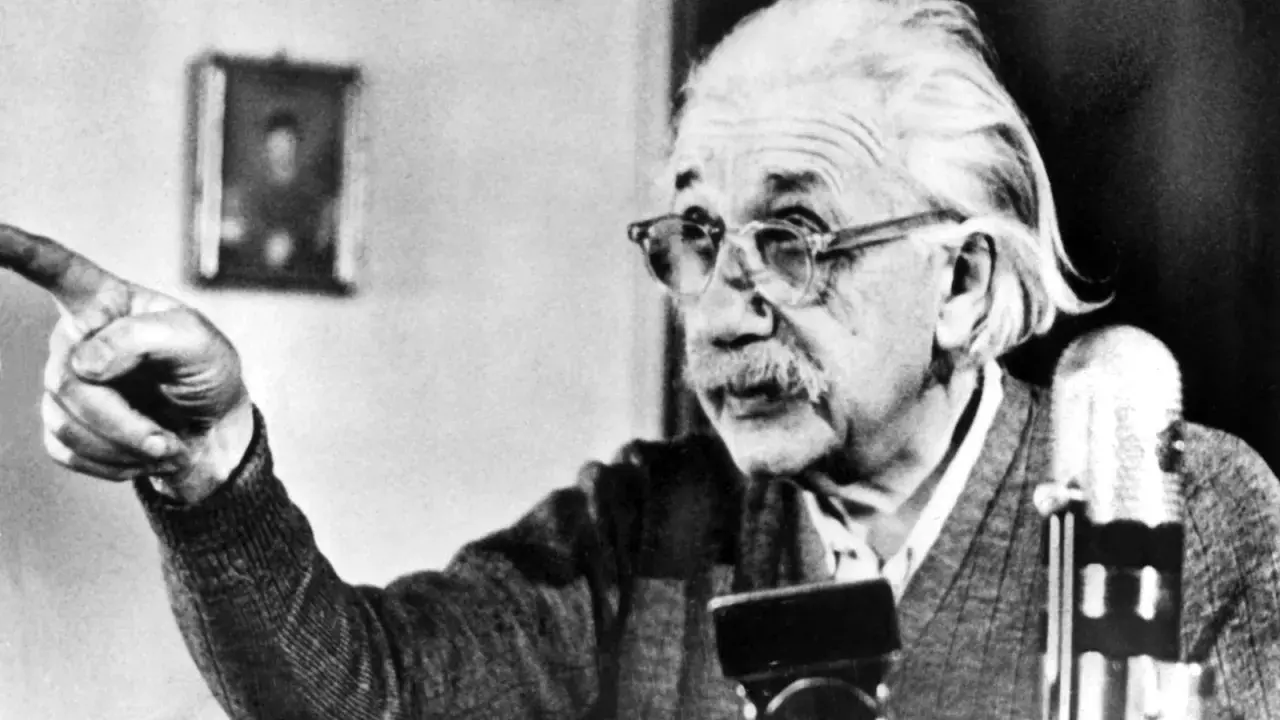Albert Einstein, mit Brille und Schnurrbart, zeigt mit dem Finger. Seine Gedanken zur Religion sind tiefgründig.