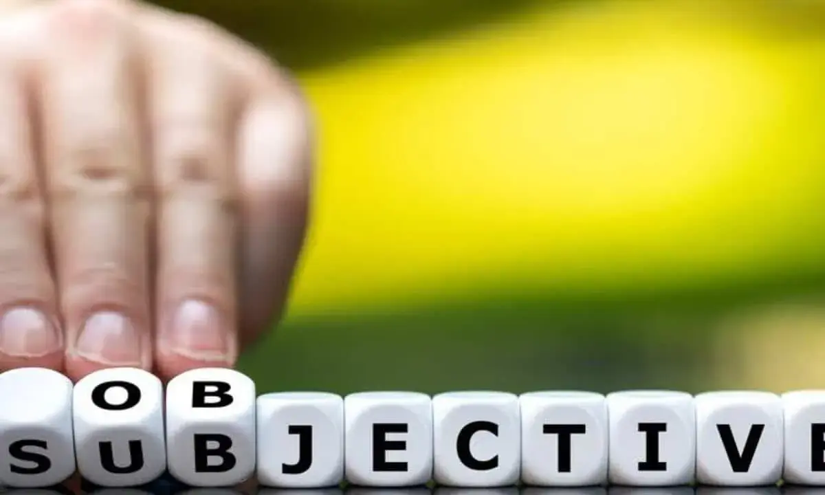 Finger tippt auf Würfel mit "SUBJEKTIV". Der Unterschied zwischen objektiv und subjektiv wird hier bildlich dargestellt.