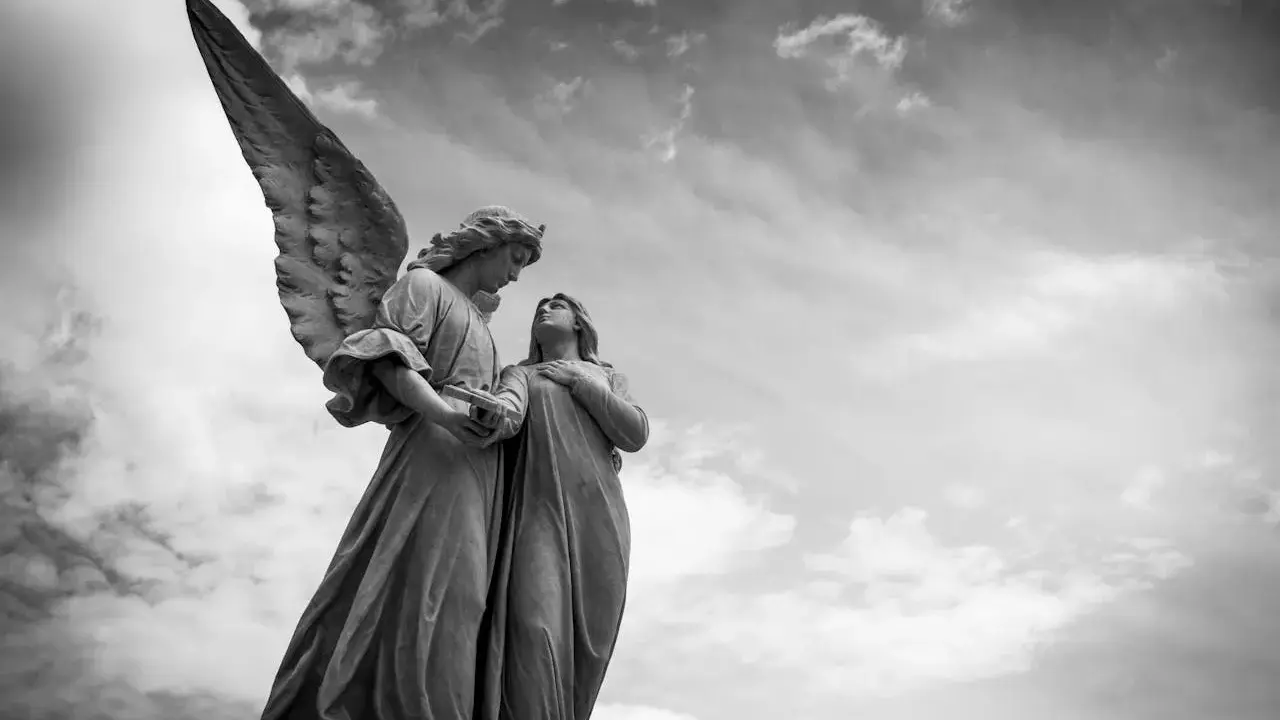 Zwei Engelsstatuen blicken sich an. Einer hält ein Buch. Die Frage, wie viele Engel es gibt, bleibt im Himmel offen.