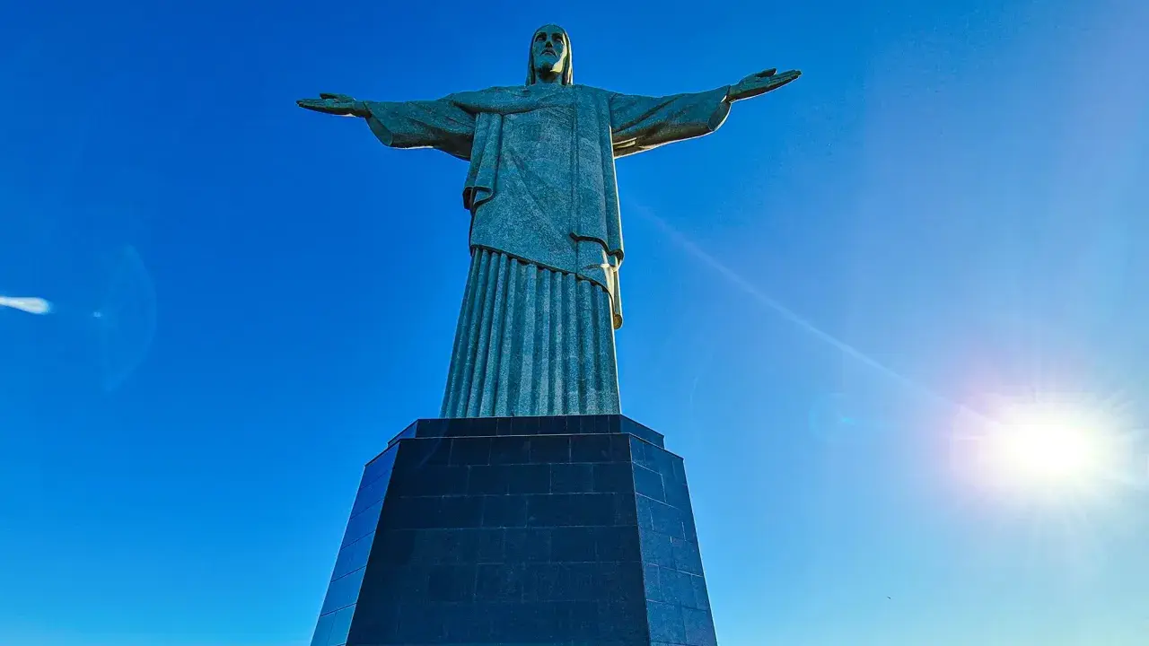 Cristo Redentor, die berühmte Statue in Rio de Janeiro, breitet seine Arme unter strahlend blauem Himmel aus.