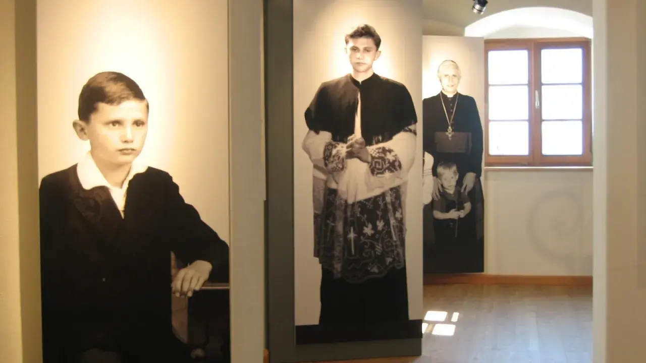 Ausstellung zeigt Maria Ratzinger in verschiedenen Lebensphasen: als Kind, junger Mann und als Geistlicher mit Kind.