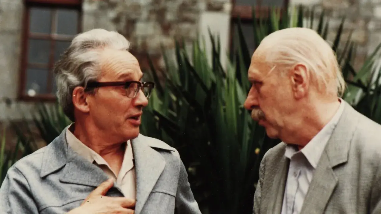 Zwei Männer im Gespräch, einer mit Brille, der andere mit Schnurrbart. Vielleicht Paul Ricoeur, der einem Kollegen seine Gedanken erklärt.