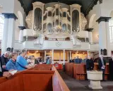 Gemeinde in einer reformierten Kirche mit imposanter Orgel.