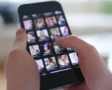 Person scrollt durch eine Galerie auf dem Smartphone, die Bilder von ethischen Pornos zeigt.