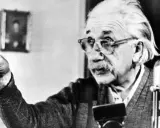 Albert Einstein, mit Brille und Schnurrbart, zeigt mit dem Finger. Seine Gedanken zur Religion sind tiefgründig.