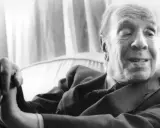 Ein älterer Mann, Georges Cuvier, sitzt nachdenklich da, seine Hand ruht auf einem Stock.