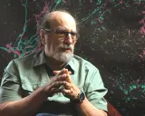 Ein Mann mit Brille und Bart, der nachdenklich seine Hände faltet. Er ist einer der bekannten Agnostiker, die über Glauben und Zweifel sprechen.