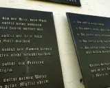 Die **10 Gebote katholisch** auf schwarzen Tafeln an einer Wand. Sie lehren uns, Gott zu ehren und den Nächsten zu lieben.