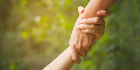 Zwei Hände greifen ineinander, ein Symbol für Hilfe und Unterstützung. Dies verkörpert die altruismus definition: selbstloses Handeln zum Wohl anderer.