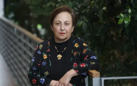 Shirin Ebadi, eine Frau mit starkem Blick, trägt eine schwarze Jacke mit bunten Blumen.