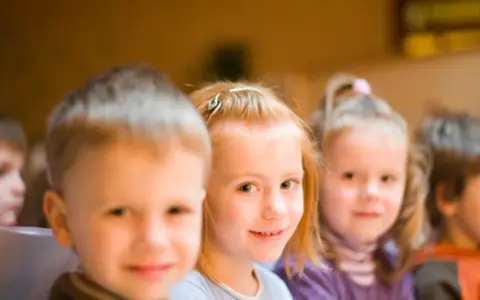 Kinder lächeln, während sie an einer episkopalen Erziehung teilnehmen.