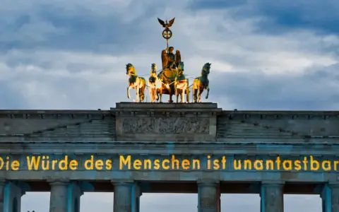 Brandenburger Tor mit leuchtender Botschaft "Die Würde des Menschen ist unantastbar." Ein Symbol für Freiheit und den Tag der Befreiung.