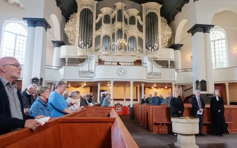 Gemeinde in einer reformierten Kirche mit imposanter Orgel.