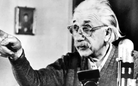 Albert Einstein, mit Brille und Schnurrbart, zeigt mit dem Finger. Seine Gedanken zur Religion sind tiefgründig.