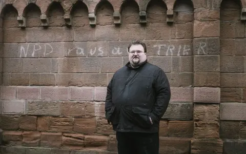 Safet Babic steht vor einer Mauer mit Graffiti.