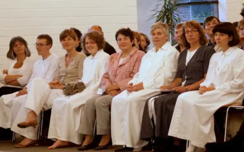 Menschen in weißen Gewändern, vielleicht bei einer Taufe. Sie sind Teil einer Gemeinschaft, die sich als Baptisten versteht.