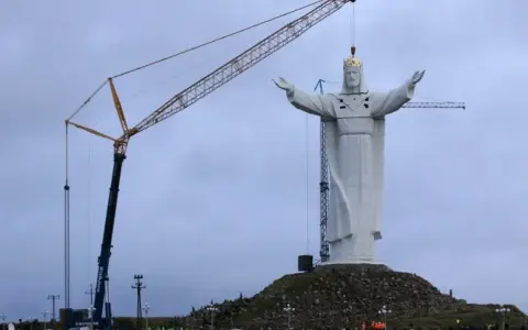 Riesige Christusstatue in Polen wird von Kränen aufgestellt.