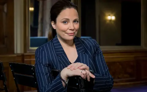 Karen Duve macht eine nachdenkliche Miene, während sie in einem gestreiften Blazer sitzt.
