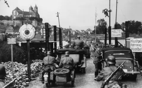 Soldaten kontrollieren Fahrzeuge an einer Grenze. Ein Schild zeigt "Douanes Françaises". Ein Blick auf die elsass geschichte.