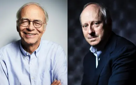 Zwei Männer, einer lächelnd mit Brille, der andere im Anzug, erinnern an die Gedanken von Michael Sandel zur Gerechtigkeit.