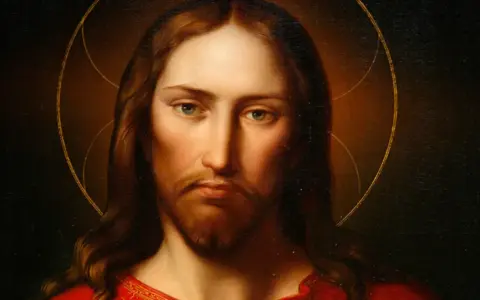 Porträt von Jesus von Nazareth mit Heiligenschein und rotem Gewand. Sein Blick ist nachdenklich und sanft.