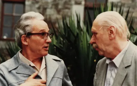 Zwei Männer im Gespräch, einer mit Brille, der andere mit Schnurrbart. Vielleicht Paul Ricoeur, der einem Kollegen seine Gedanken erklärt.