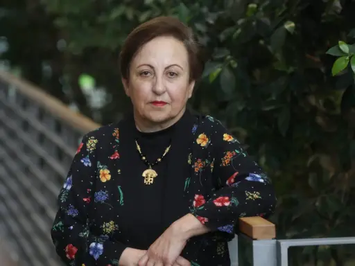 Shirin Ebadi, eine Frau mit starkem Blick, trägt eine schwarze Jacke mit bunten Blumen.