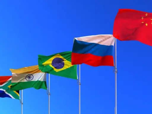 Fünf Flaggen (Südafrika, Indien, Brasilien, Russland, China) wehen im Wind. Die BRICS-Bedeutung wird durch diese Länder repräsentiert, die eine wachsende globale Rolle spielen.