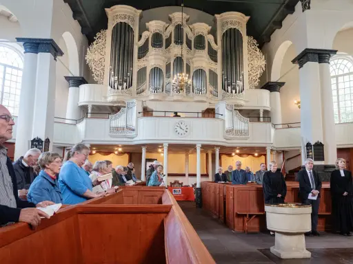 Gemeinde in einer reformierten Kirche mit imposanter Orgel.