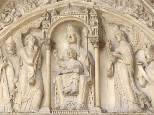 Steinrelief mit Maria und Kind, flankiert von Heiligen und Engeln. Die Bedeutung von Saint Germain wird hier durch die Darstellung von Heiligen und biblischen Szenen unterstrichen.