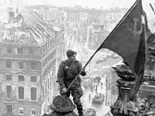 Ein Soldat hisst am 8. Mai die Flagge über den Ruinen Berlins.