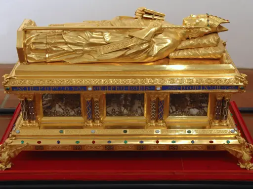 Vergoldete Reliquien-Truhe mit liegender Figur, die ein Buch und einen Stab hält. Ein kostbares Zeugnis der Reliquien Jesu.