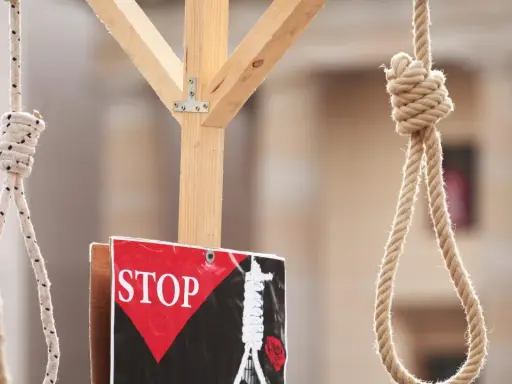 Galgenstricke und ein "STOP"-Schild symbolisieren die Todesstrafe im Iran.