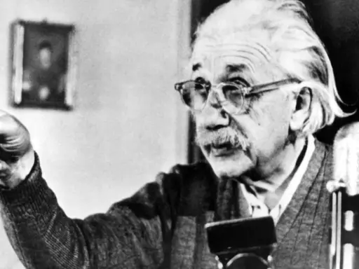Albert Einstein, mit Brille und Schnurrbart, zeigt mit dem Finger. Seine Gedanken zur Religion sind tiefgründig.