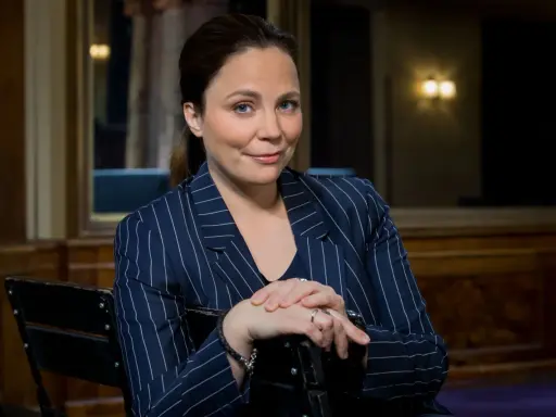 Karen Duve macht eine nachdenkliche Miene, während sie in einem gestreiften Blazer sitzt.