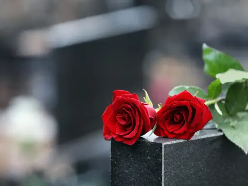 Zwei rote Rosen auf einem Grabstein, ein Symbol der Erinnerung 40 Tage nach dem Tod im katholischen Glauben.