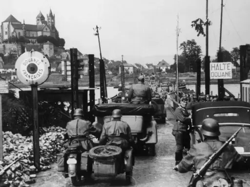 Soldaten kontrollieren Fahrzeuge an einer Grenze. Ein Schild zeigt "Douanes Françaises". Ein Blick auf die elsass geschichte.