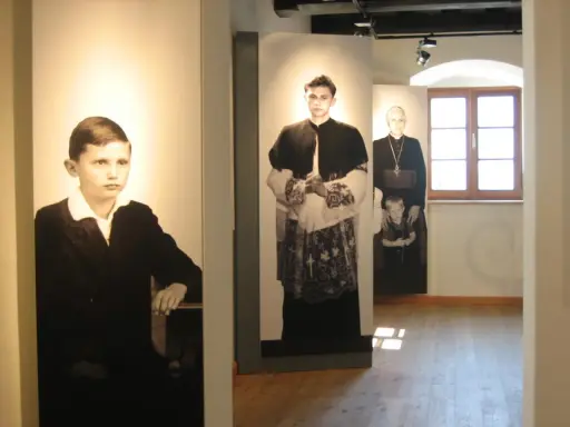 Ausstellung zeigt Maria Ratzinger in verschiedenen Lebensphasen: als Kind, junger Mann und als Geistlicher mit Kind.