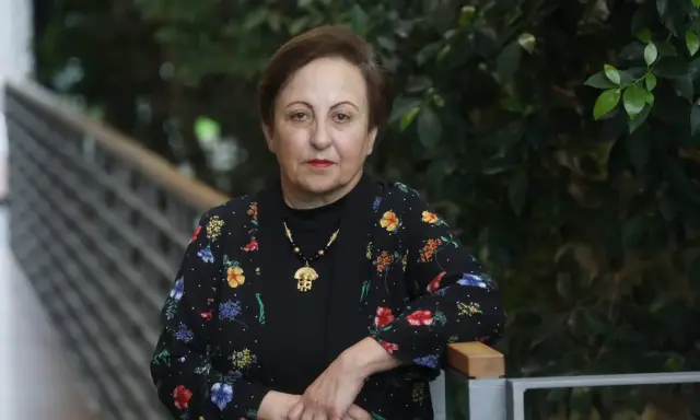 Shirin Ebadi, eine Frau mit starkem Blick, trägt eine schwarze Jacke mit bunten Blumen.