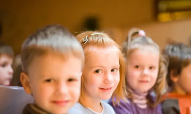 Kinder lächeln, während sie an einer episkopalen Erziehung teilnehmen.
