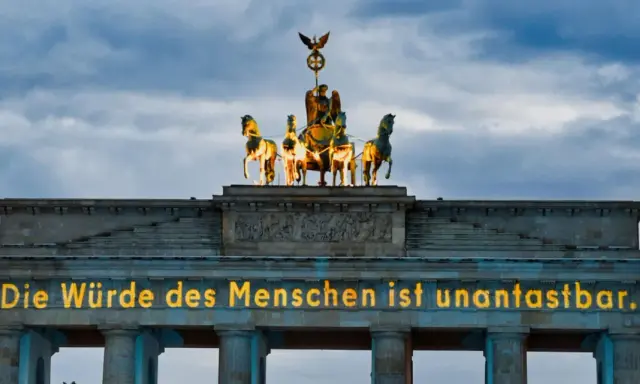 Brandenburger Tor mit leuchtender Botschaft "Die Würde des Menschen ist unantastbar." Ein Symbol für Freiheit und den Tag der Befreiung.
