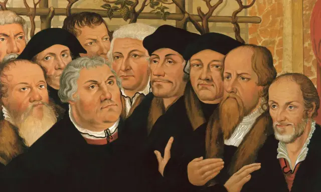 Porträtgruppe von Reformatoren, darunter Martin Luther und John Calvin, mit ernsten Blicken und prächtigen Gewändern.