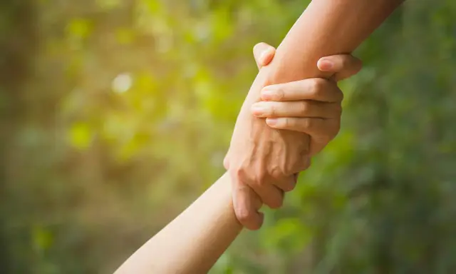 Zwei Hände greifen ineinander, ein Symbol für Hilfe und Unterstützung. Dies verkörpert die altruismus definition: selbstloses Handeln zum Wohl anderer.