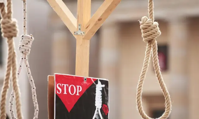 Galgenstricke und ein "STOP"-Schild symbolisieren die Todesstrafe im Iran.
